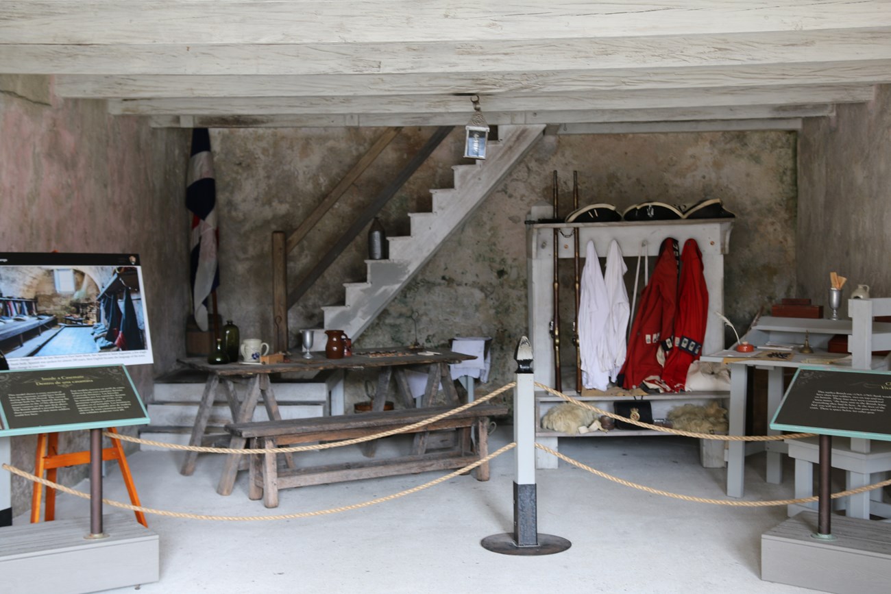 British room with uniforms, table items, desk reproductions on display.