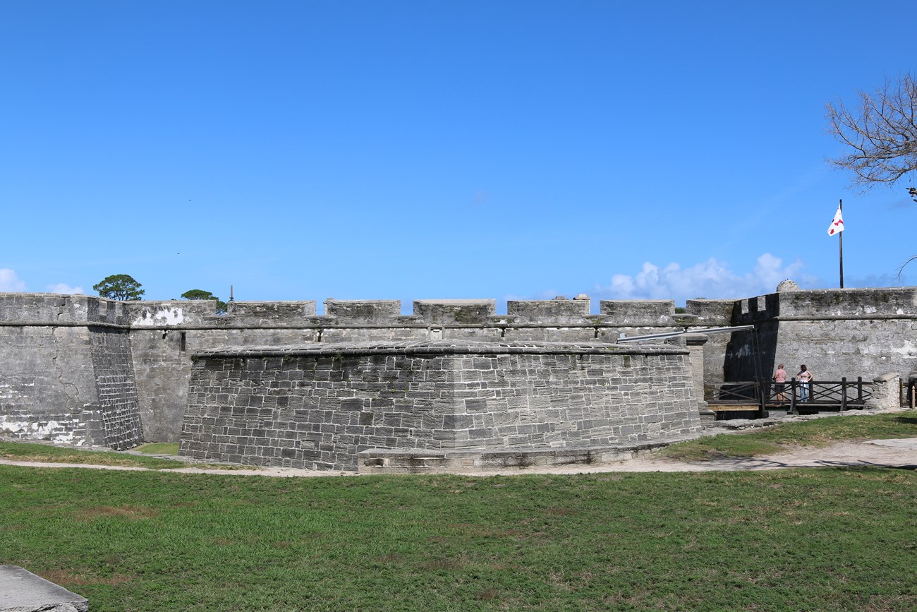 Southern wall and ravelin. Blue sky above and green grass below.