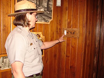 NPS Ranger turning off LED light switch in the exhibit located in the visitor center