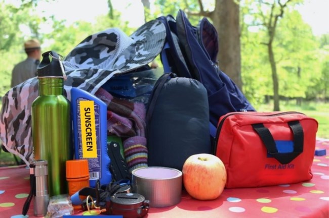 Hiking essentials such as food, first aid kit, water, and sun protection