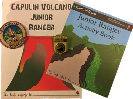 Two Junior Ranger books side by side with a round patch and plastic badge.