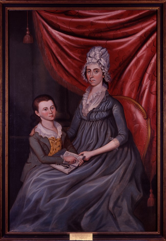 A portrait painting shows a seated woman and boy in fancy 1700s clothes.