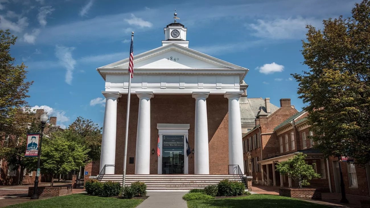 Historic brick courthouse with four large columns.
