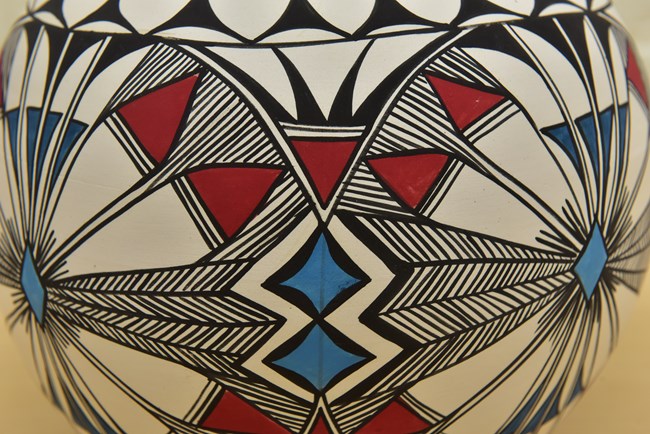 A closeup view of the black, red, and blue designs on a buff-colored background.