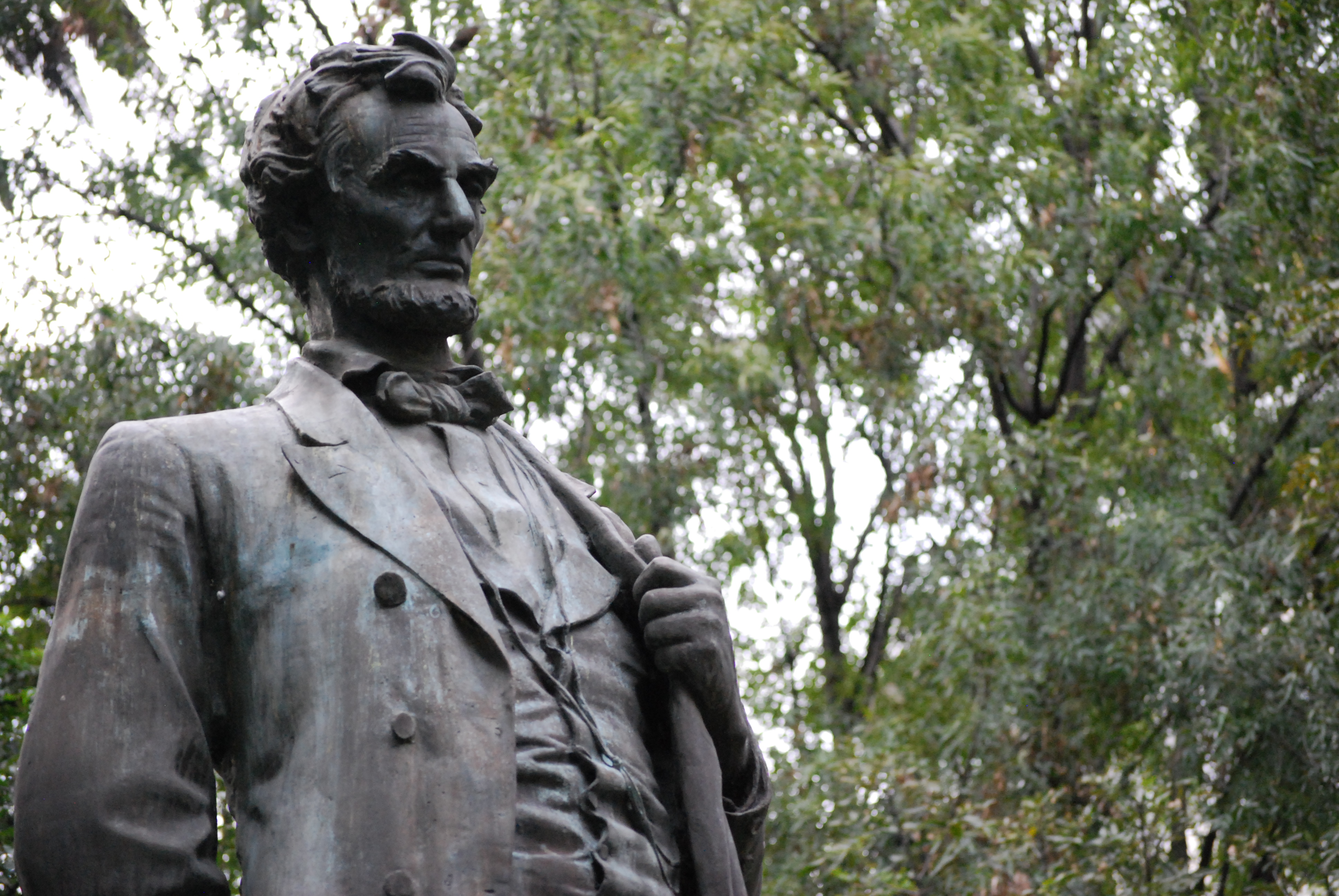 La cabeza y torso de una estatua de Abraham Lincoln, parado, agarrando la solapa de su saco con la mano izquierda
