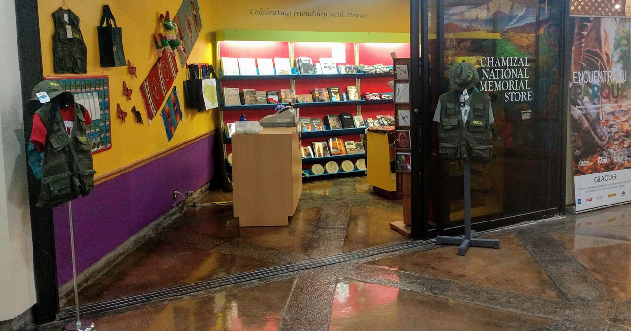 opening of park store reveals colorful walls and merchandise such as junior ranger vests, textiles, books, and cards