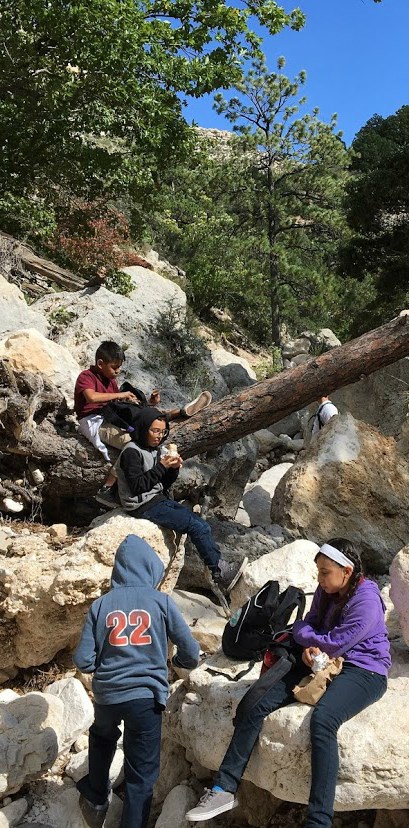 kids sitting on boulders in a draw