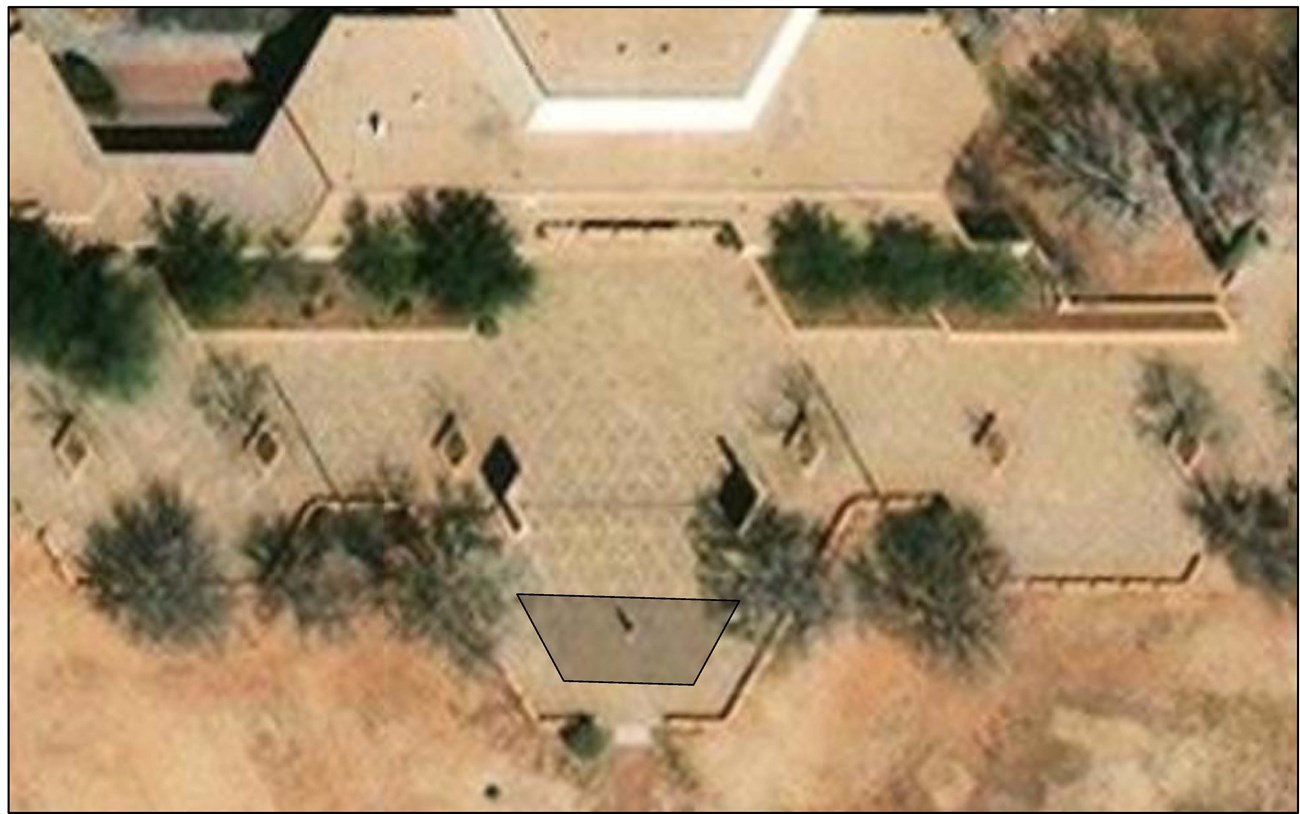 Aerial perspective of park cultural center and office building with paved area extending along the bottom side of them. A trapezoid-shaped area is highlighted on the paved walkway in front of the cultural center.