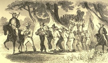 A group of enslaved people chained together and escorted by white men on horseback