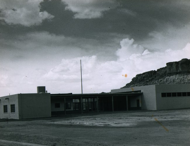 A black and white historic photo from 1958 of the Chaco visitor center building in a canyon.