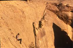 A man sitting on the ledge of a cliff hang.
