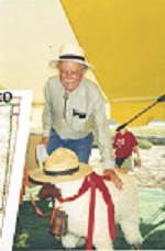 David M Brugge smiling while petting a stuff animal wearing a flathat.