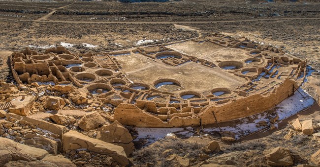 The remains of a large great house seen from above, showing tall walls and multiple kivas.