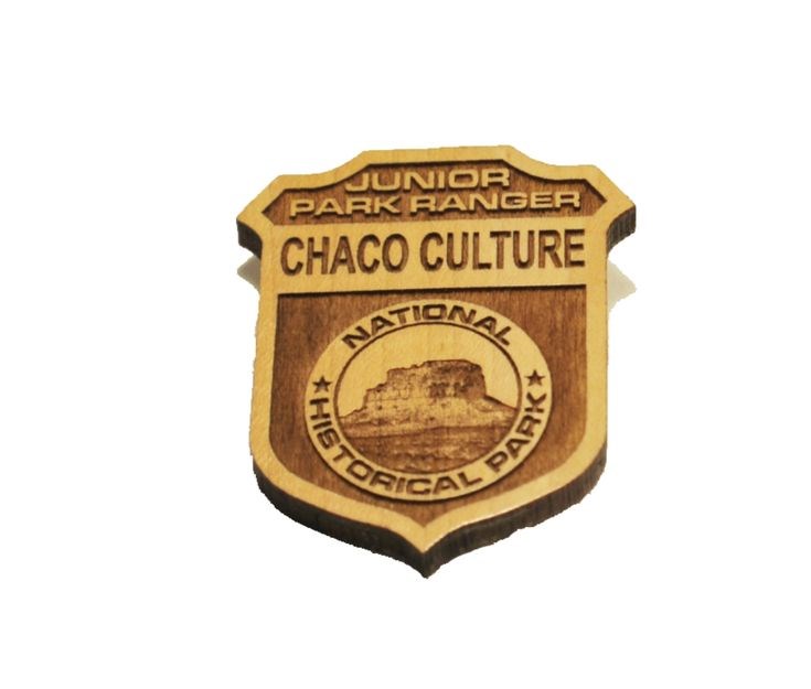 A wooden badge that says Junior Park Ranger Chaco Culture National Historical Park.