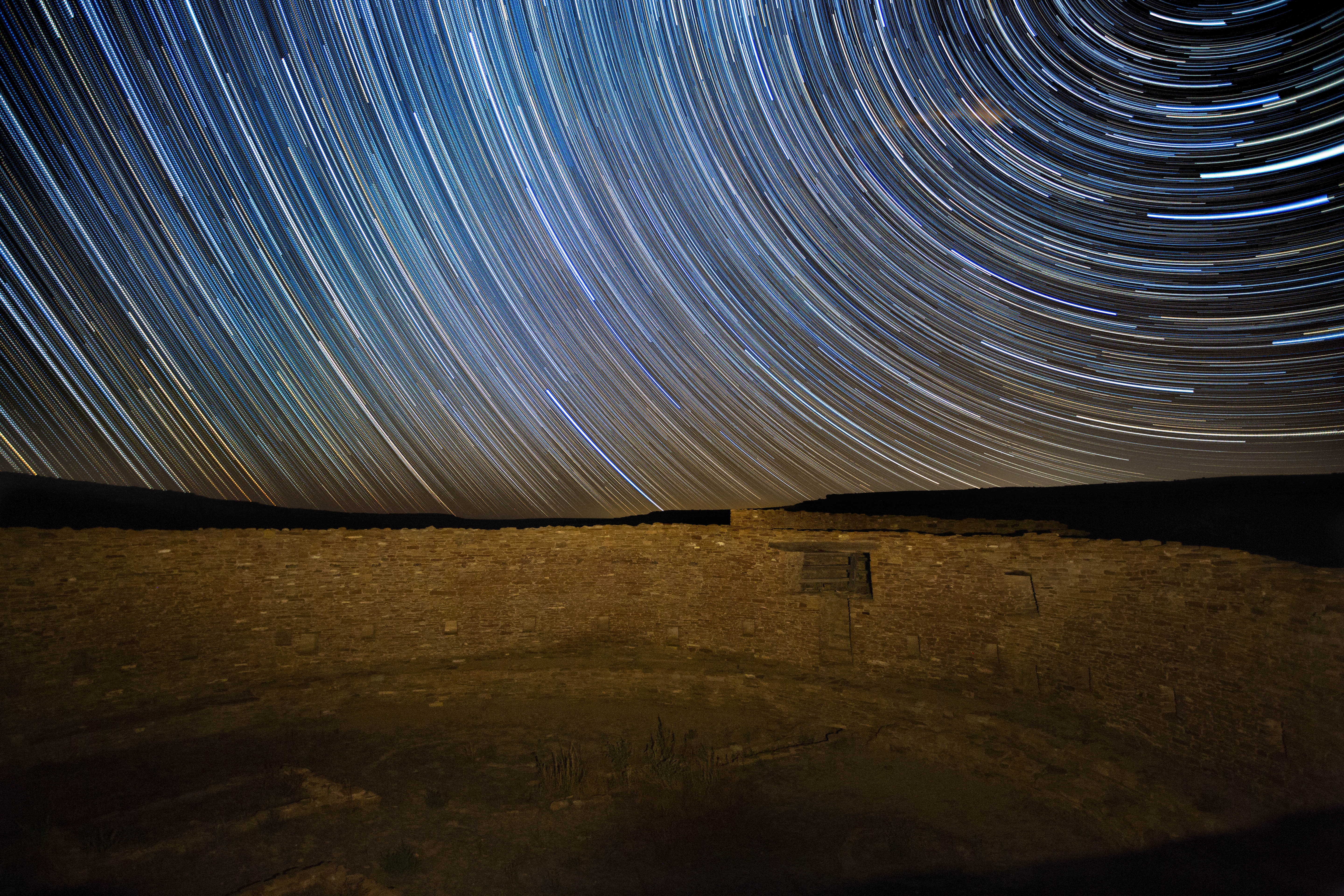 Star trails over a masonry wall.