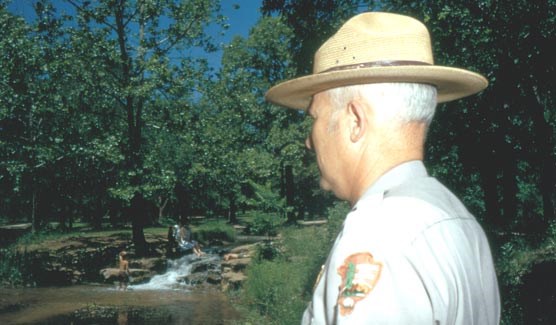 Park ranger observing visitors swimming, circa 1970