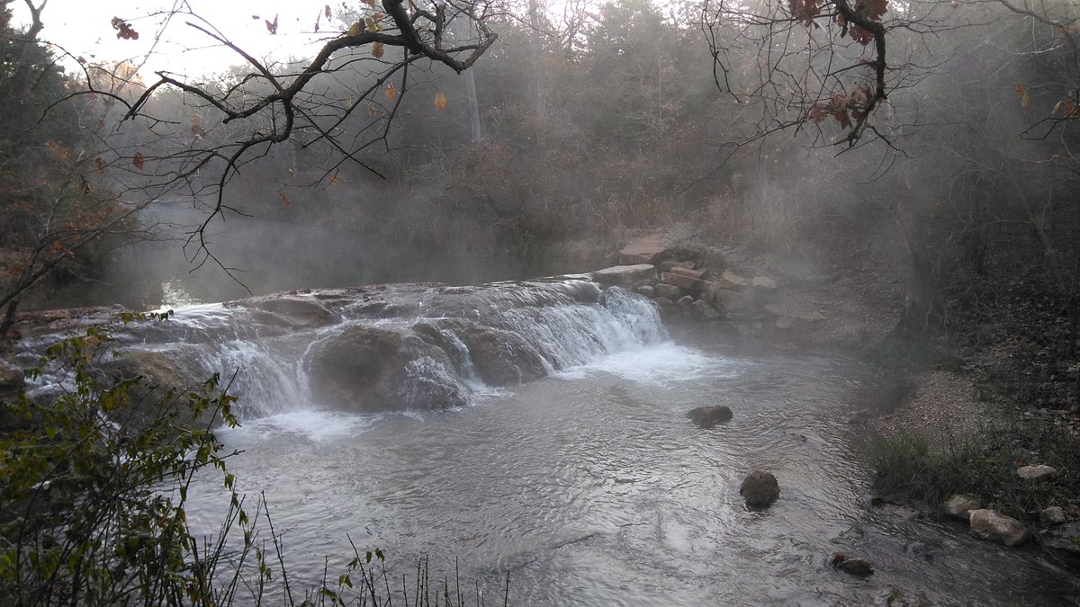 A small waterfall surrounded in mist on a winter morning.