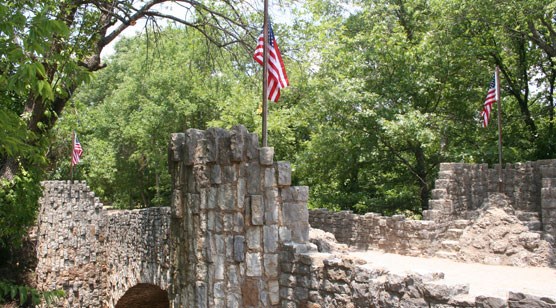 American flags fly on the turrets of a stone bridge