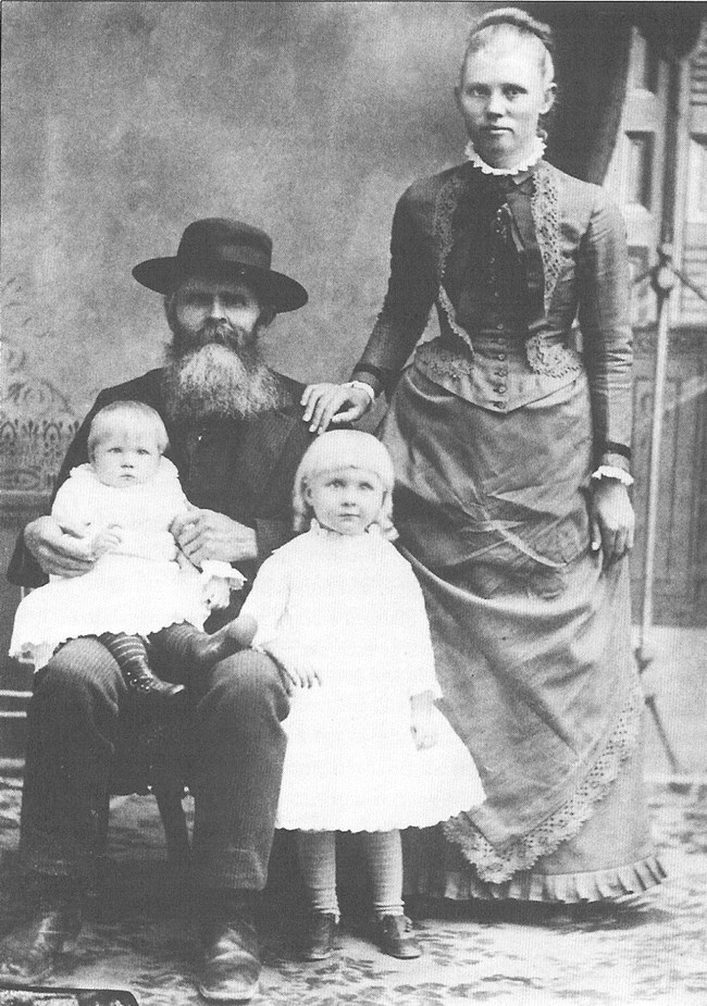 Black and white portrait of a man and woman and two young girls.