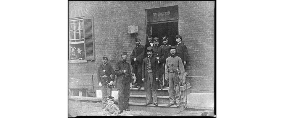 Historical black and white photo of Officers at the door of Seminary Hospital in Georgetown, Washington, DC, during the Civil War.