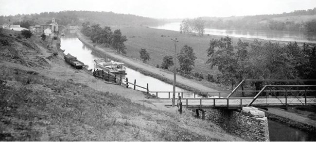 A view of the watered C&O Canal, with a canal boat in the water.