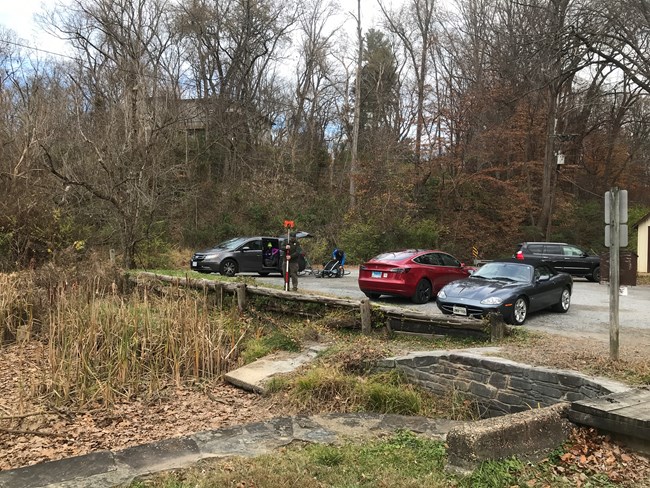 A wooden timber wall holds up a parking area