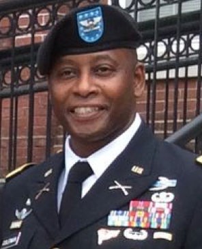 A man in an army uniform wearing a dark colored beret
