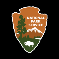 The NPS arrowhead logo showing a bison, a lake, a mountain, trees all on an arrowhead outline.