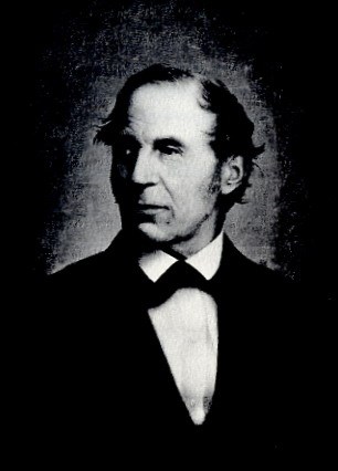 A older man in a suit is posing for a portrait.