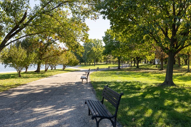 A paved pathway leads to the Constitution Gardens and is lined with benches about every 10 feet.