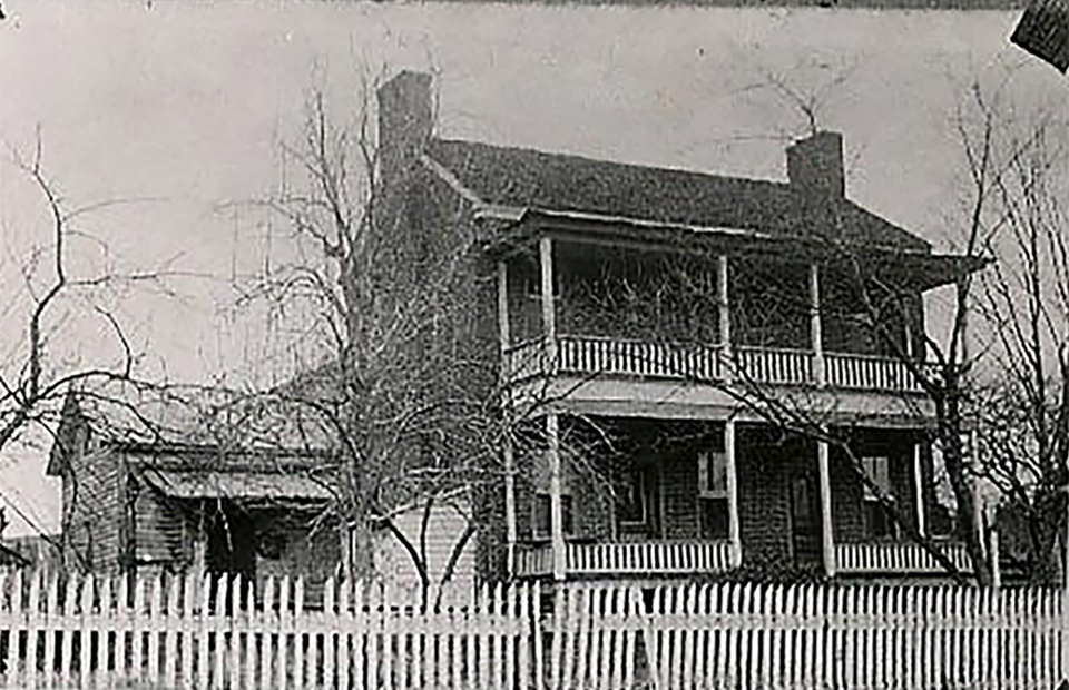 A two story brick building with white trim and two doors.