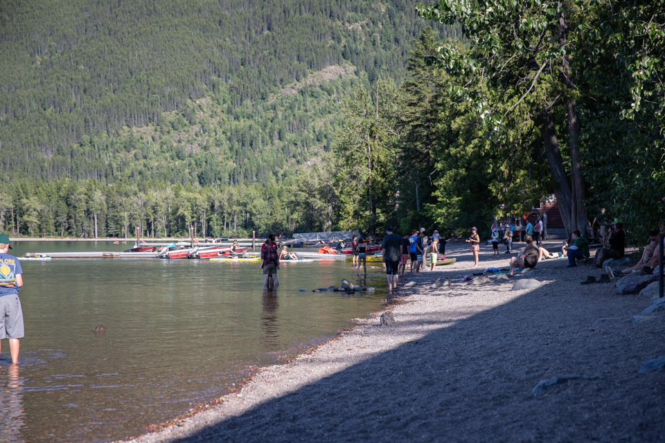 People stand on a beach in sunny weather.