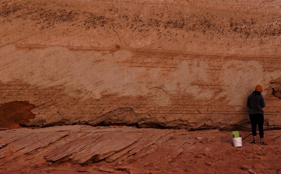 Sandstone wall covered with scratched on graffiti