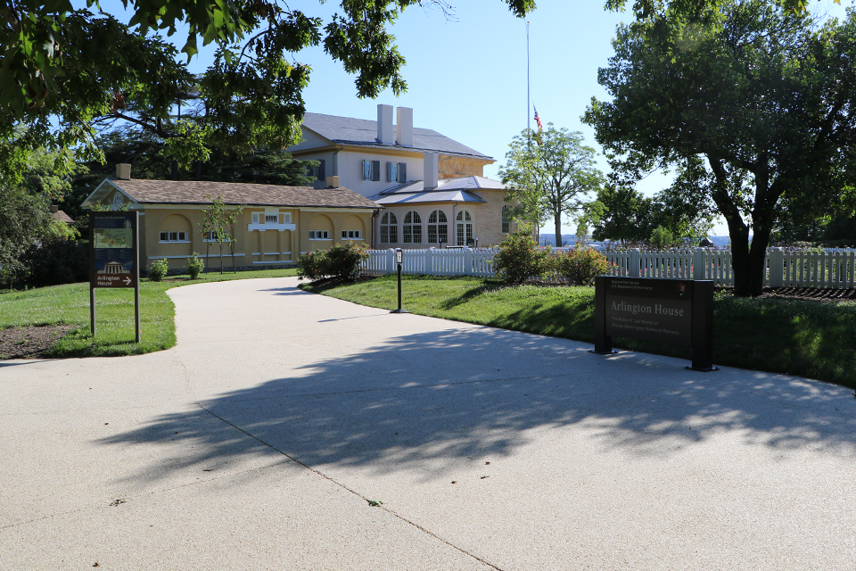 A gravel entrance to a site with run down signage.