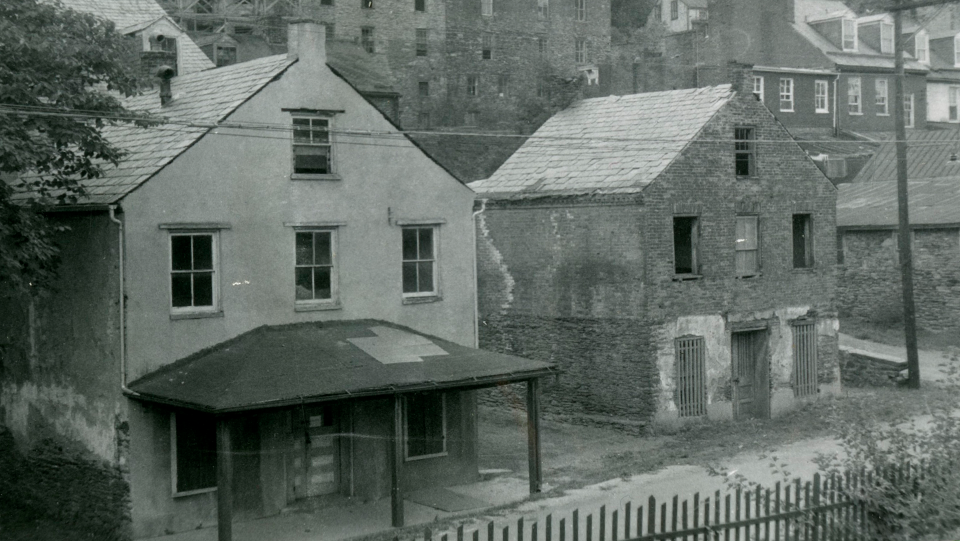 black and white photo of two buildings in need of repair