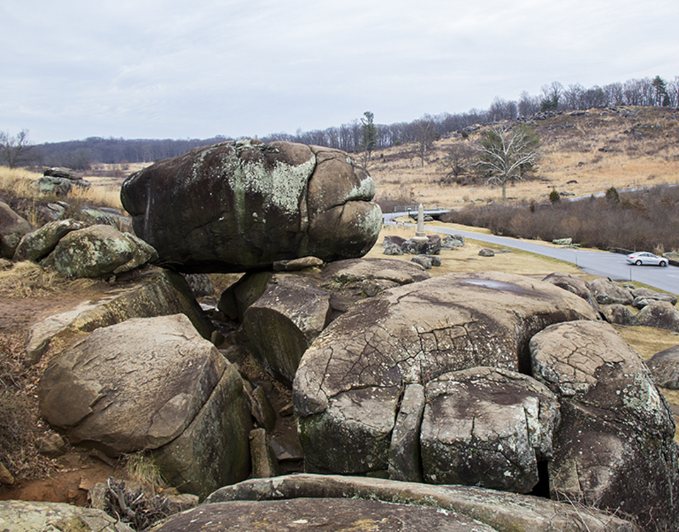 Historic view of the boulders of Devil's Den also shows the western slope of Little Round Top in the distance to the right.