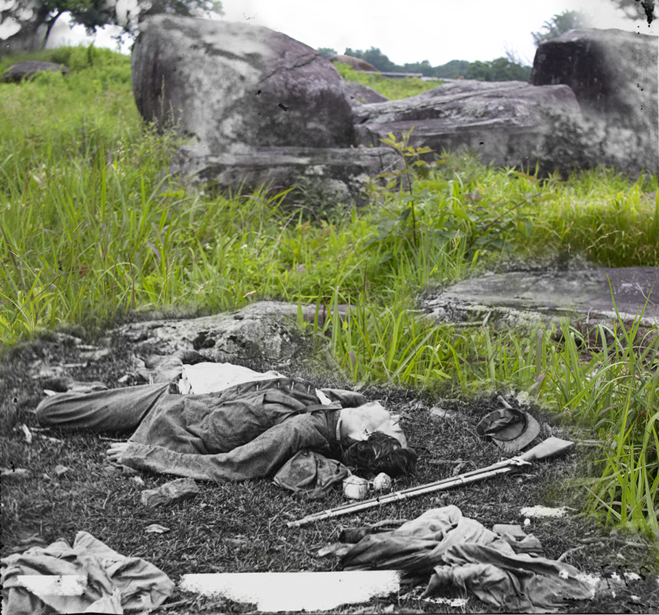 A dead soldier lies in front of rocks near Devil’s Den.