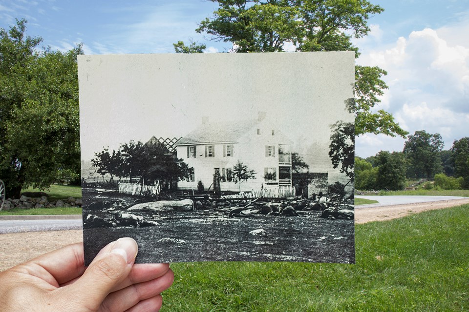 A historic picture of the Trostle house, held up in the center of the modern version, shows numerous dead horses from Bigelow's Battery.