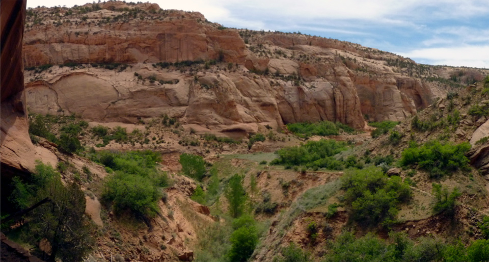 Black-and-white photo showing sandy canyon bottom with sharp gully