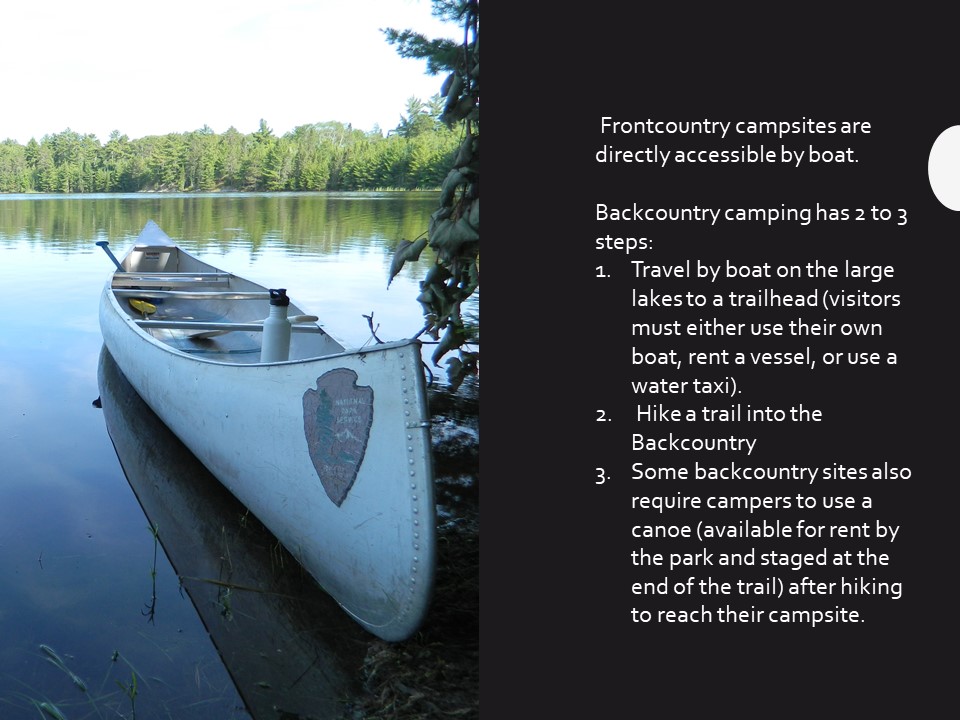 A canoe with the national park service logo sits in the water.