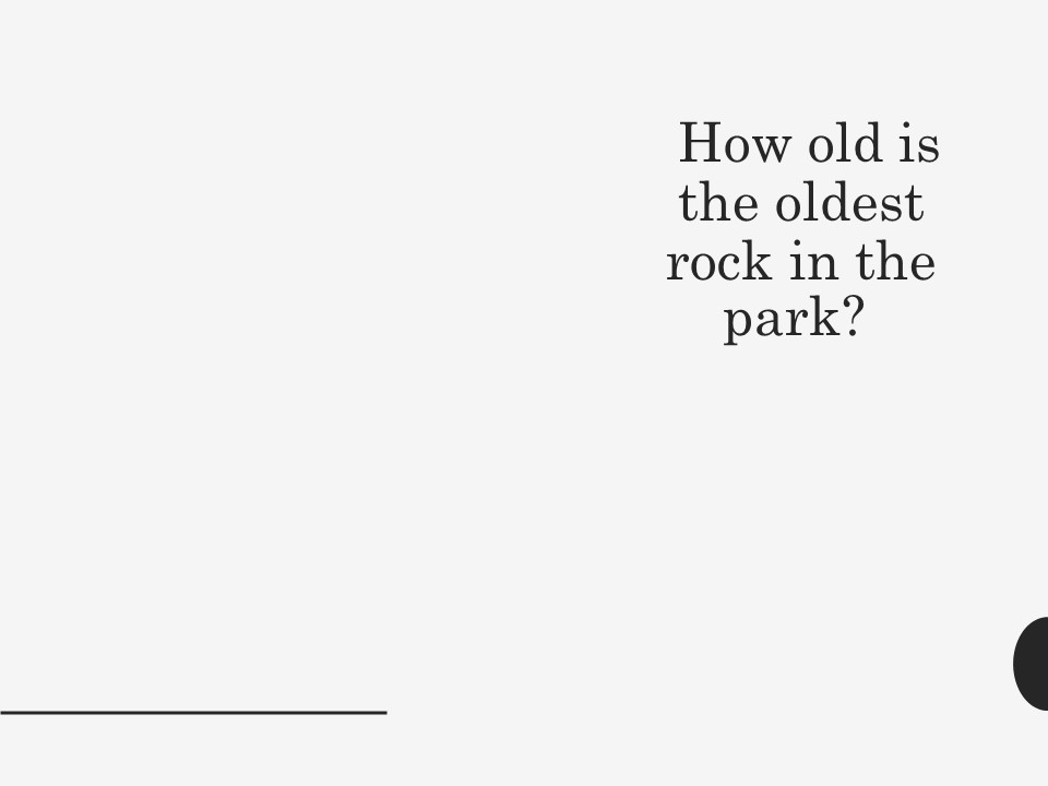 A glacial erratic (large rock) in sitting in a large body of water.