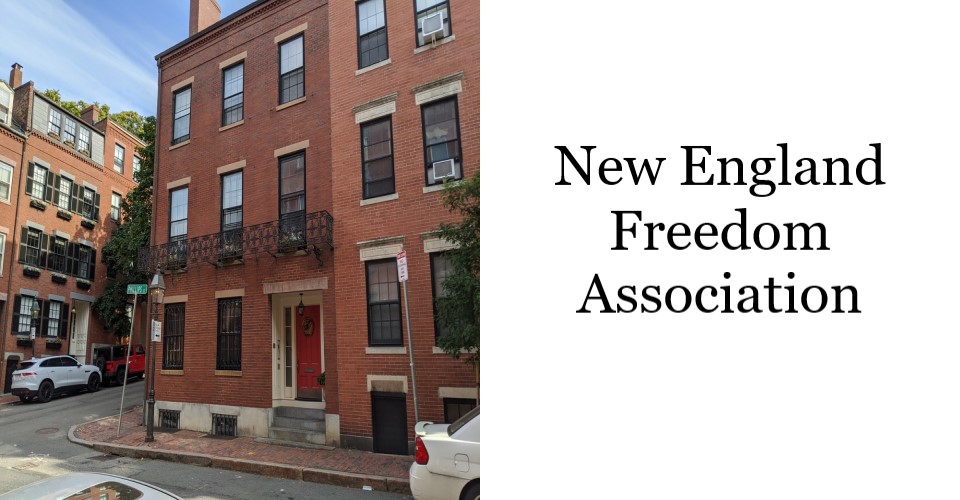 Three story brick row house at a street corner. Doorway is on the right side of house against neighboring unit. A faux balcony railing in cast iron is in front of the second story windows.
