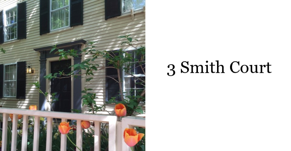 A photo of the William Cooper Nell house on Smith Court. The 2 story building is yellow with a white fence in front.