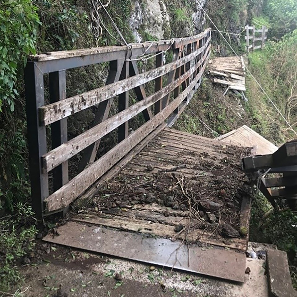 Upper Pali Trail bridge destroyed by severe weather with scattered debris and missing boards