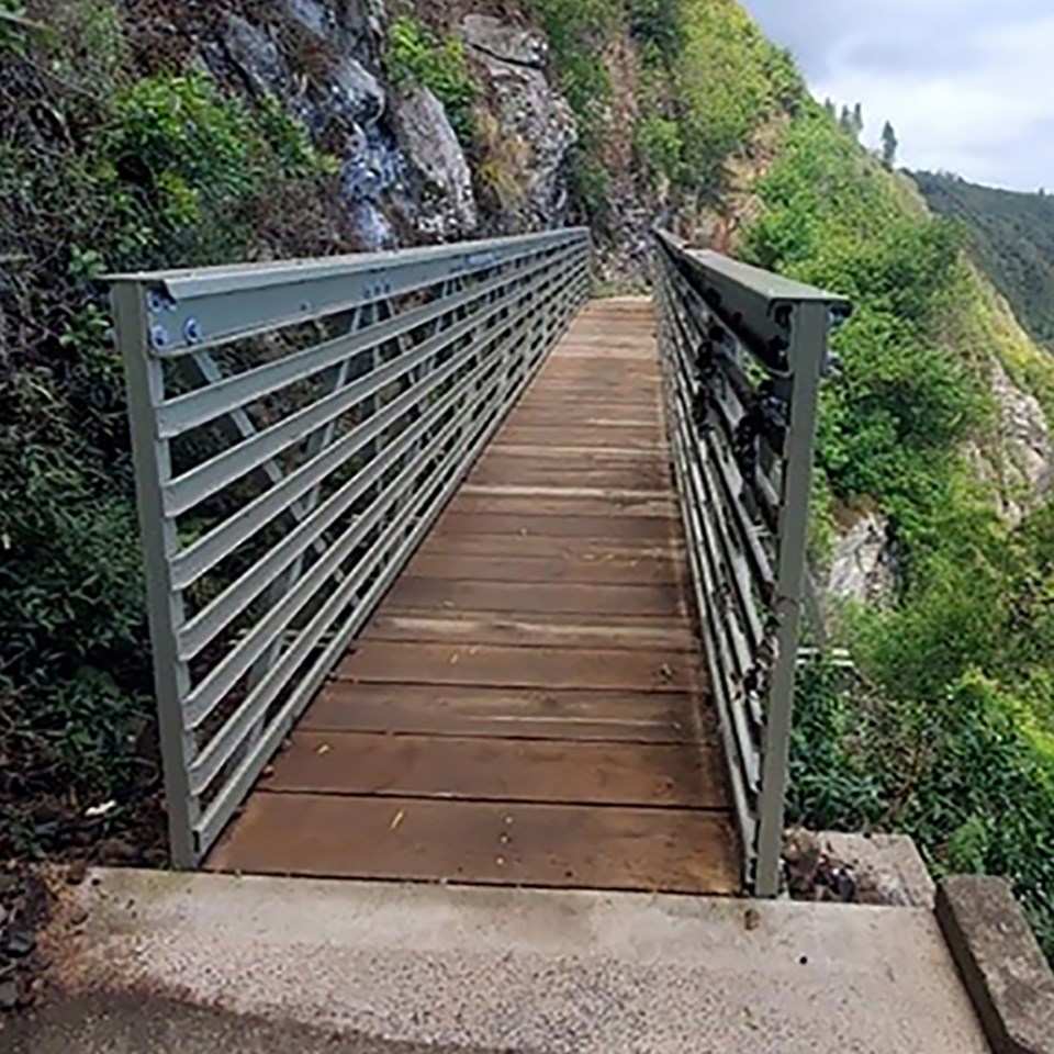 Upper Pali Trail bridge destroyed by severe weather with scattered debris and missing boards