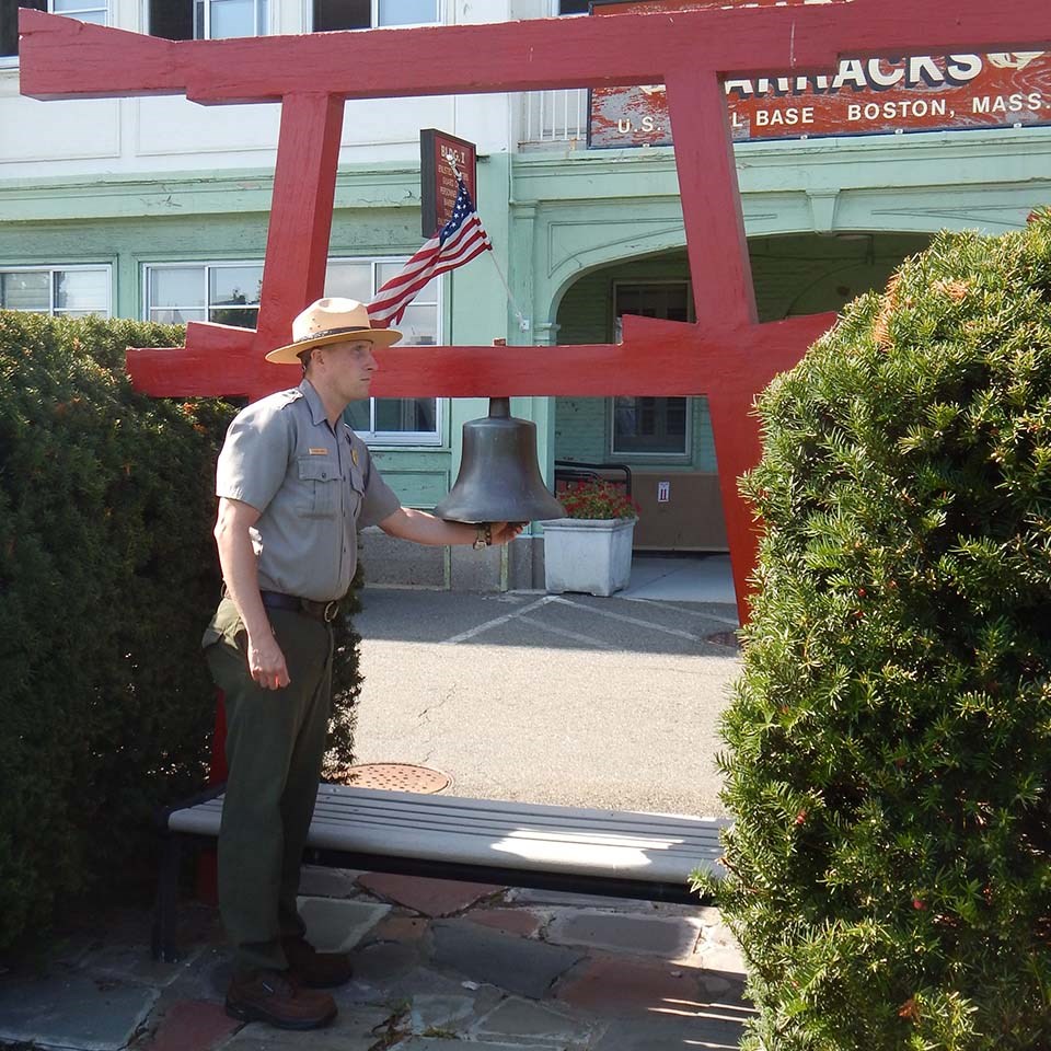Image of Marine ringing bell on red Shinto torii gate, accompanied by a dog