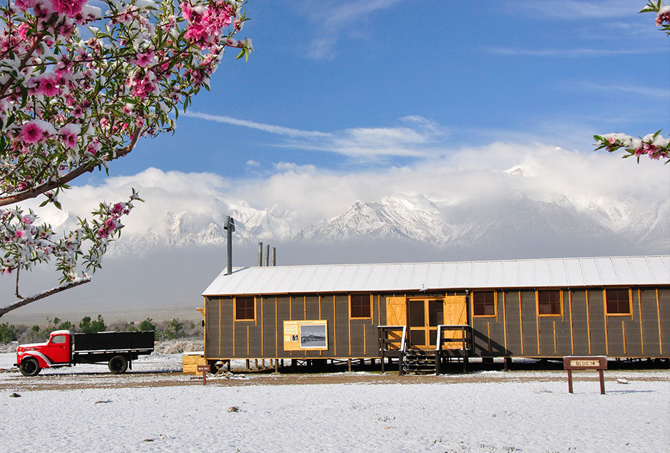 Two old run down barracks buildings being transported by trailer