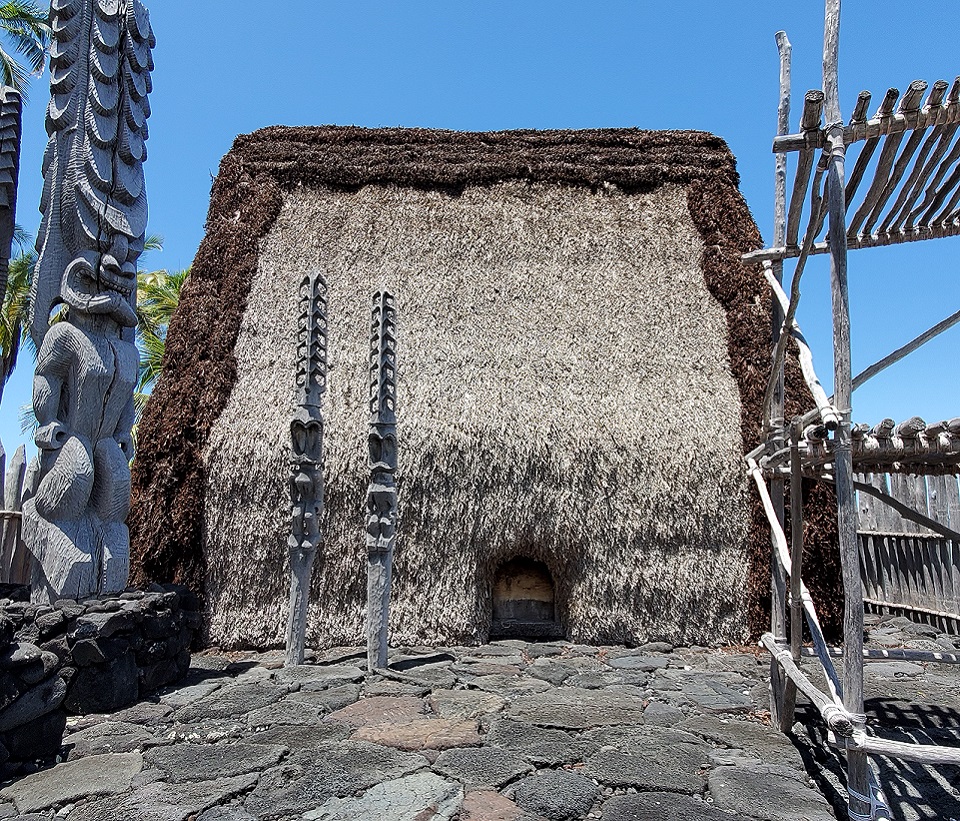 Men build the scaffolding for the original reconstruction of Hale o Keawe, Park Ranger walking in front