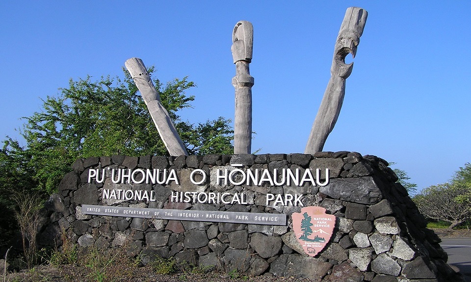 City of Refuge National Historical Park entrance sign with three carved kiʻi