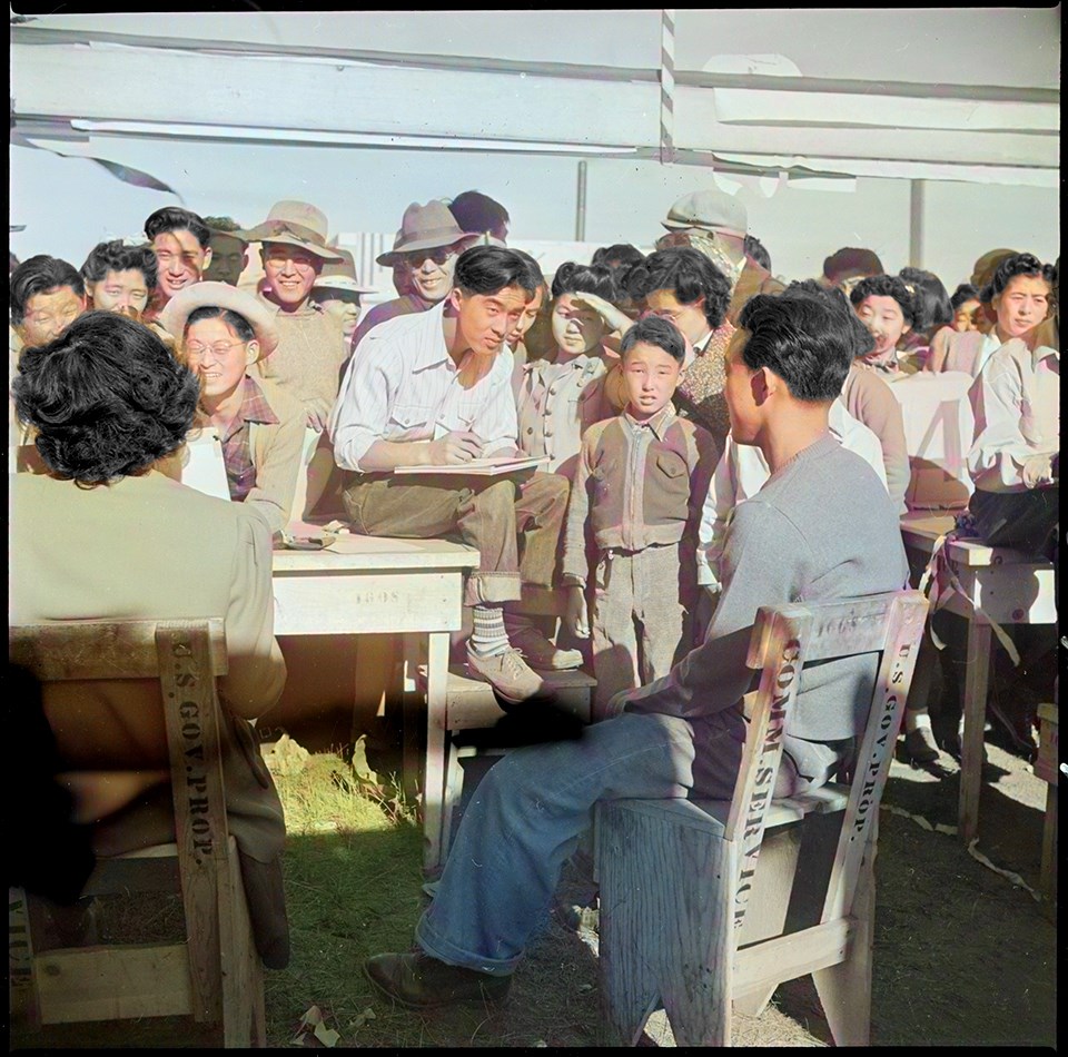 Tule Lake Relocation Center, Newell, California. Harvest Day Festival. An artist sketches one of the festive throng in the concessionary.